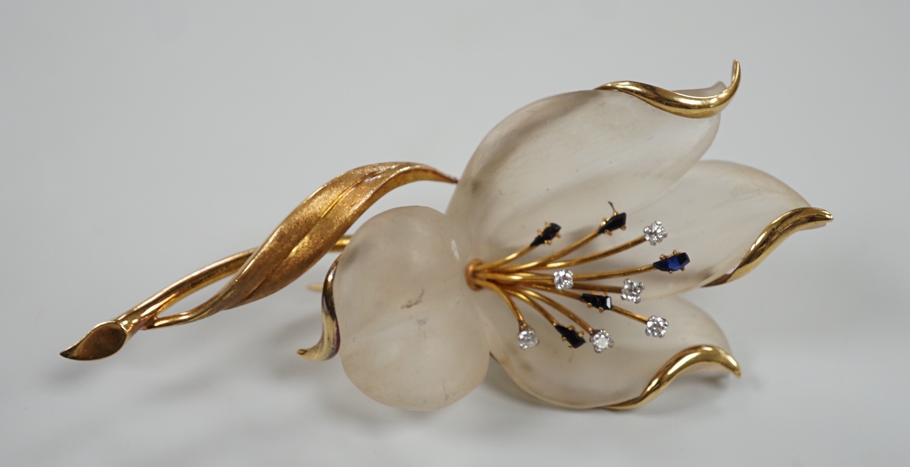 A modern continental yellow metal, sapphire and diamond set frosted glass? flower clip brooch, 85mm, gross 25.8 grams.